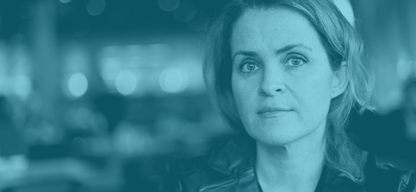 A woman looks directly at the camera